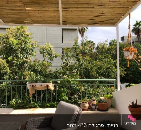מרפסת עם גג במבוק וצמחייה מסביב